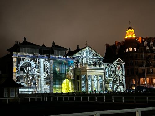 a building covered in lights with a clock on it at Ailim House Serviced Cottage Escape, around the corner from the Old Course in St. Andrews