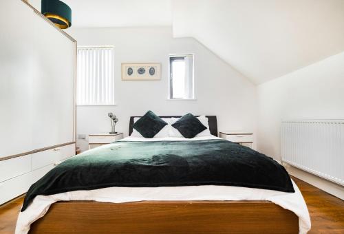 a bedroom with a large bed in a white room at Meersbrook Luxury Duplex Apartment in Sheffield