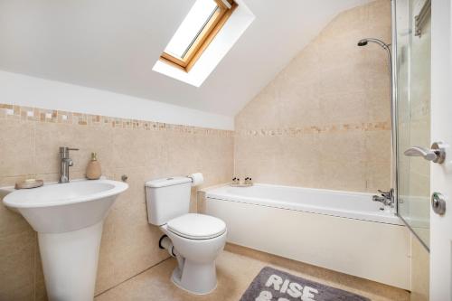 a bathroom with a toilet and a sink and a bath tub at Meersbrook Luxury Duplex Apartment in Sheffield