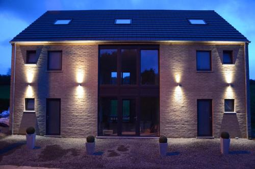 a brick house with lights on the side of it at La Chambre Du Pèlerin in Foy-Notre-Dame