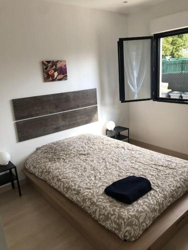 sypialnia z łóżkiem i oknem w obiekcie Charment logement avec parking et jardin privatif w mieście Rocbaron