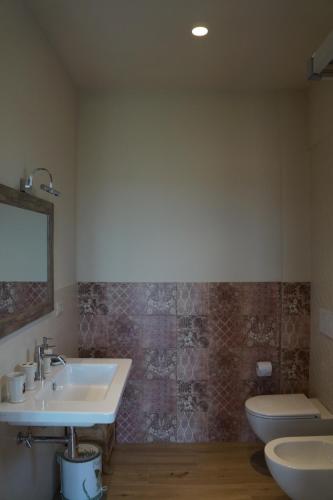 a bathroom with a sink and a toilet and a mirror at La Sperella Bed and Breakfast in Fermo