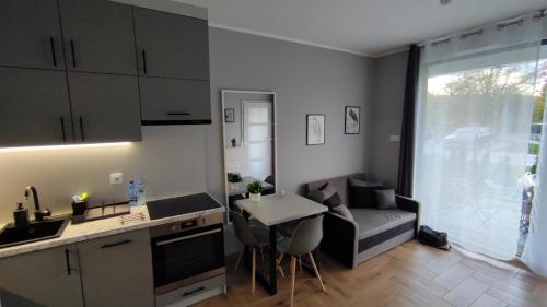 een keuken en een woonkamer met een tafel en een bank bij Apartament Orla 47F Perłowa Dolina in Bydgoszcz