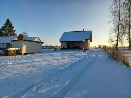 a snow covered road with a house in the distance at Chalupa Na blátě in Hoješín
