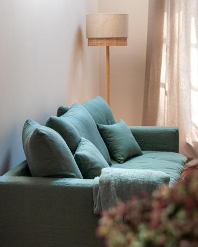 a green couch with pillows on it in a living room at Domaine Mont-Riant à Jurançon in Jurançon