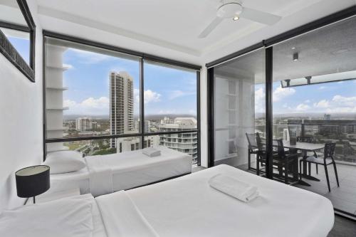 a bedroom with two beds and a large window at Circle on Cavill - HR Surfers Paradise in Gold Coast