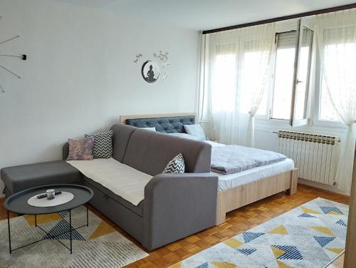 a living room with a couch and a bed at Apartman F&S - Novo Sarajevo in Sarajevo