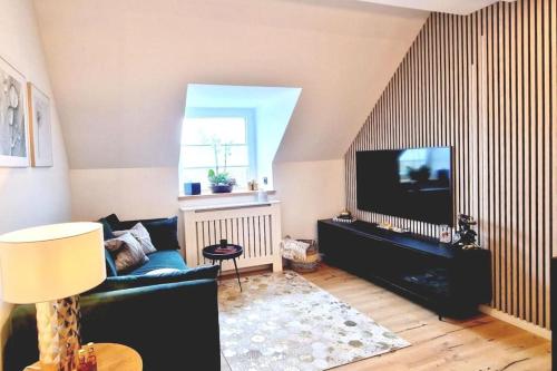 a living room with a couch and a flat screen tv at Stilvolle Maisonette Wohnung in Karlsruhe