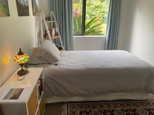 a bedroom with a large white bed with a window at Harbour View Retreat Mangonui in Mangonui