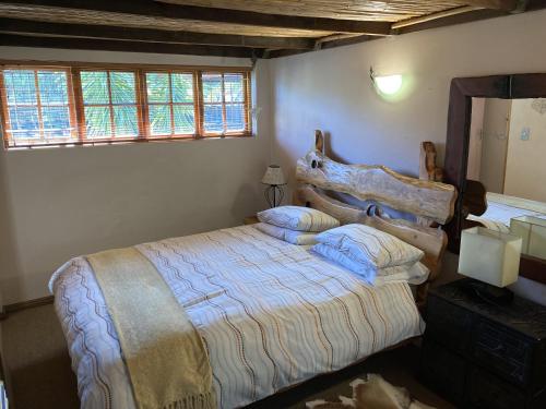 a bedroom with a large bed with a wooden headboard at Paradise in Kommetjie in Cape Town