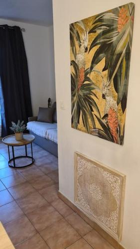 un salon avec un canapé et un tableau au mur dans l'établissement Studio meublé en face du golf côté piscine, à Mouans-Sartoux