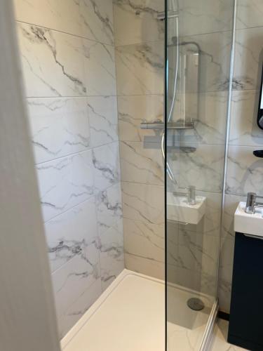 a bathroom with a glass shower with a sink at Jolly Sailors Retreat in Wells next the Sea