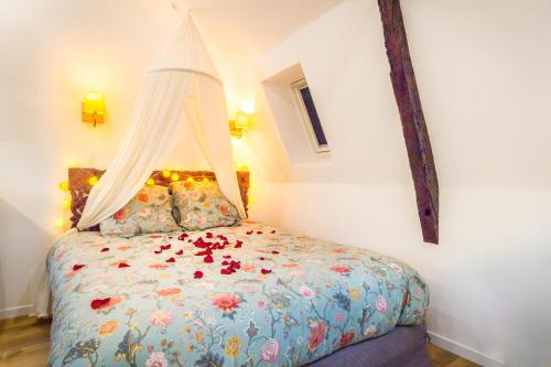 Un dormitorio con una cama con flores. en Jacuzzi® - La petite Romantique - FloBNB en Laon