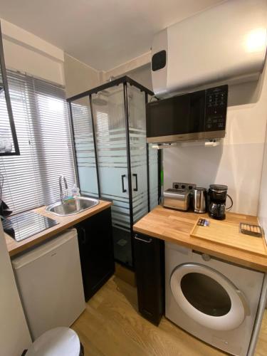 une petite cuisine avec un comptoir et un évier dans l'établissement Cozy studio Paris 5ème métro Jussieu/Sorbonne, à Paris