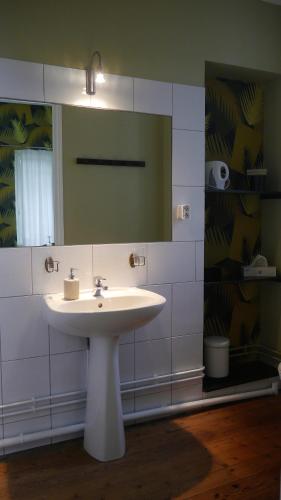 a bathroom with a white sink and a mirror at Maison Castel Braz in Pont-Aven