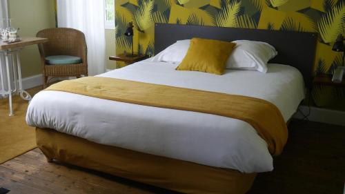 a bedroom with a large bed with a yellow pillow at Maison Castel Braz in Pont-Aven