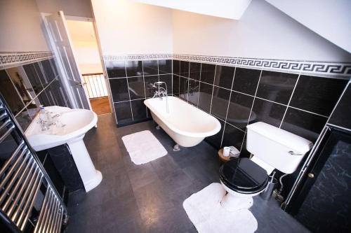 a bathroom with a sink and a tub and a toilet at Beautiful Sea View, Whitburn, South Tyneside 