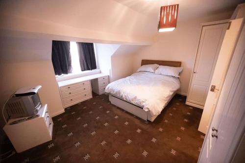 a small bedroom with a bed and a television at Beautiful Sea View, Whitburn, South Tyneside 