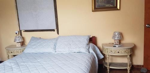 a bedroom with a bed with two nightstands and two lamps at La Quimera a pasos de la playa in Atlántida