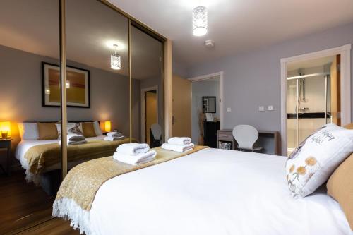 Habitación de hotel con 2 camas y espejo en Black Moon -2-bed,2-bath - Central location- Southampton, en Southampton