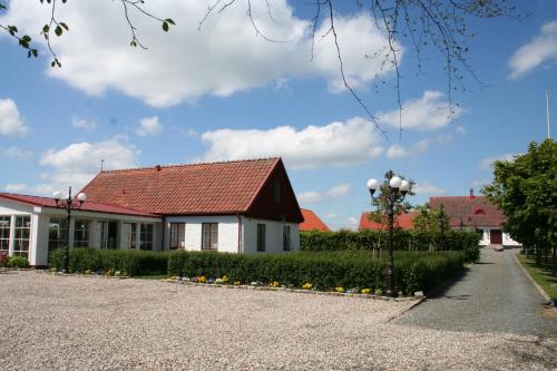 a building with a red roof and a street light at Hoby Gård in Borrby