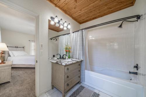 baño con bañera y lavamanos y cama en Luxury Rock Creek Cabin w Deck by Lake Hamilton, en Hot Springs