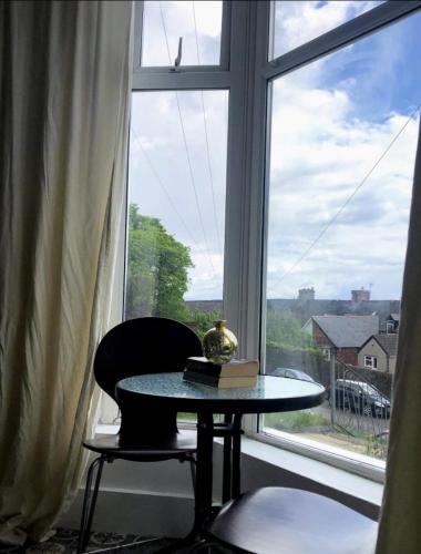 a table and a chair in front of a window at Uplands View, Richmond Tce, Flat 1 in Swansea