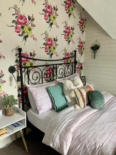 a bedroom with a bed with flowers on the wall at Uplands & Channel View, Richmond Tce, Uplands in Swansea