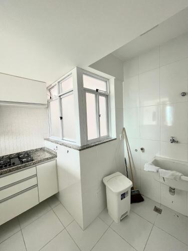 a white bathroom with a sink and a toilet at Eu Amo Arraial Hospedagem - Luz do Sol Prainha in Arraial do Cabo