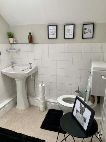 a bathroom with a toilet and a sink and a table at Uplands & Channel View, Richmond Tce, Uplands in Swansea
