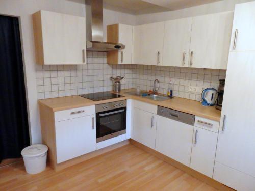a kitchen with white cabinets and a sink at Ferienwohnung Haus Maier in Seeboden