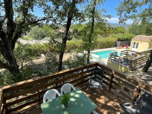 une terrasse avec une table et des chaises ainsi qu'une piscine dans l'établissement Le Dourmidou - Gite avec piscine, au pied du Luberon, à Oppède
