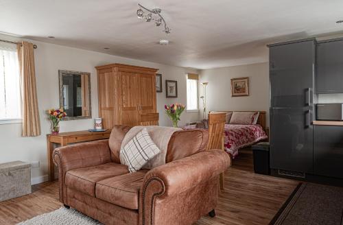 a living room with a couch and a refrigerator at Courtyard Bothy in Grantown on Spey