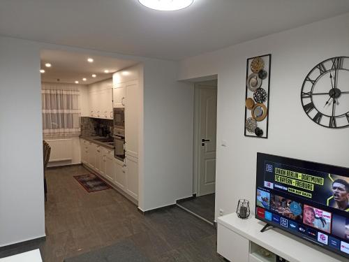 a kitchen with a television and a clock on the wall at EBS Paradies in Rheinhausen