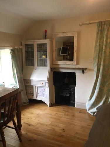 Old Mutlow Cottage في Longhope: غرفة معيشة مع موقد وتلفزيون