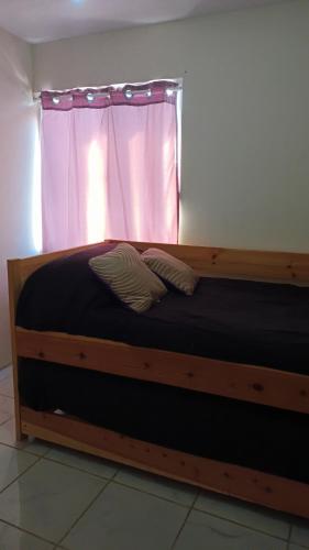 - une chambre avec un lit en bois et une fenêtre dans l'établissement Airport Hostel, à Ciudad Juárez
