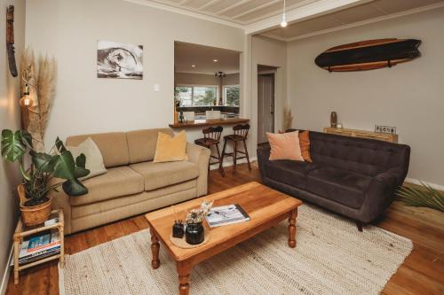 a living room with a couch and a coffee table at The Ocean Villa - Private Sauna in New Plymouth