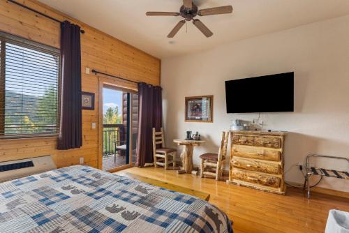 a bedroom with a bed and a flat screen tv at Gateway Inn in Grand Lake