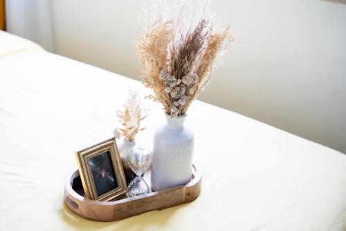 - un plateau en bois avec un vase, une photo et une horloge dans l'établissement Paris Homestay of Happyness, au Kremlin-Bicêtre