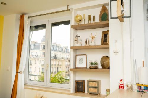 ein Wohnzimmer mit einem Fenster und Regalen in der Unterkunft Paris Homestay of Happyness in Le Kremlin-Bicêtre