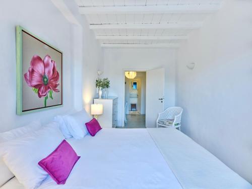 biała sypialnia z dużym białym łóżkiem z różowymi poduszkami w obiekcie Villa Light w mieście Vourkari
