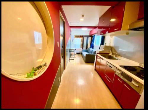 a kitchen and a living room with a red wall at MELL-THEATE - Nibiironokaze - in Osaka