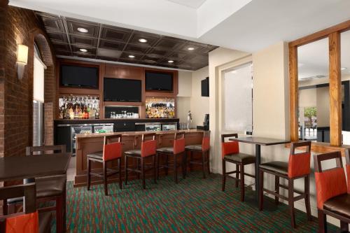 a bar in a restaurant with red chairs and tables at Days Inn by Wyndham Baltimore Inner Harbor in Baltimore