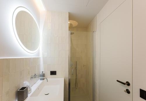 y baño con ducha, lavabo y espejo. en Easylife - Spazioso e tranquillo trilocale in Porta Romana, en Milán