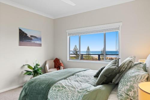 a bedroom with a bed and a large window at 22 Dulling Street Beach House in Dalmeny