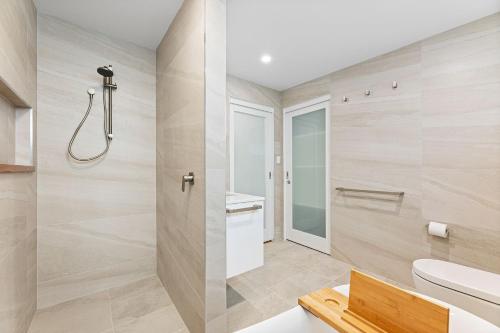 a bathroom with a shower and a toilet at 22 Dulling Street Beach House in Dalmeny