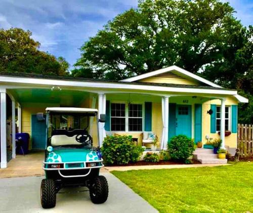 a golf cart parked in front of a house at Downtown- Sunshine Cottage and Golf Cart in Southport