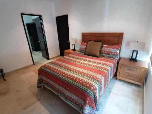 um quarto com uma cama colorida e um espelho em Casa Dahlia em Mazatlán