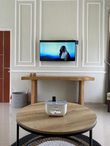 ein Wohnzimmer mit einem Couchtisch und einem TV in der Unterkunft The Naya Villas Private Pool in Karangploso