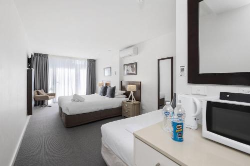 pokój hotelowy z dwoma łóżkami i telewizorem z płaskim ekranem w obiekcie Resort Family Two Bedroom 109 w mieście Torquay